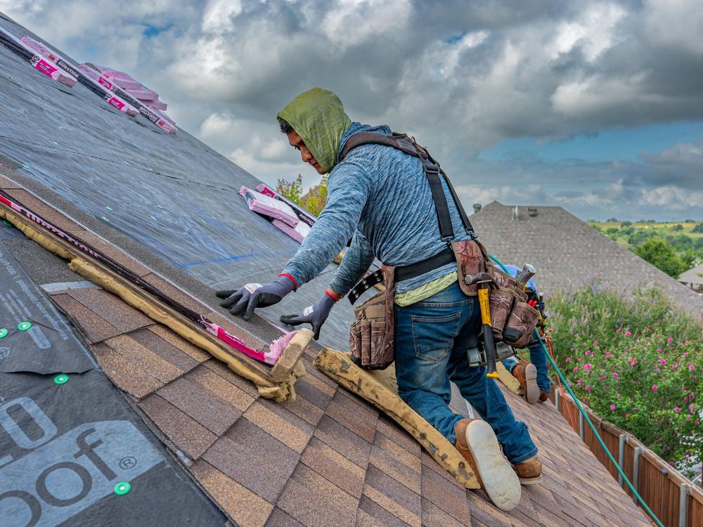 Roofer installing shingles